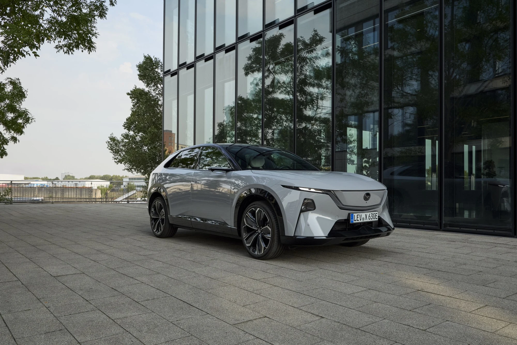 Mazda CX-6e elétrico branco estacionado junto a um edifício